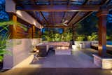 As the sun sets, the serenity of the indoor-outdoor space is aglow from the custom fire pit.  Contemporary mixed materials of cypress and stone, tile and timbers creates this exotic and secluded lounging area.