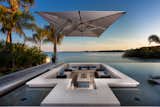 Glistening waters surround this well-appointed outdoor retreat highlighted by a bespoke infinity pool, spa and waterfall features. A custom designed sunken fire lounge appears to float within the 19’ x 38’ tile encircled pool. From the Florida family’s home, the outdoor space delivers a seamless view linking the water features to the glass-like waters of the Gulf of Mexico. 