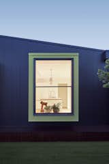 One of the two window boxes is painted a vivid lime green in contrast to the dark charcoal toned paneling.