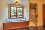 Soaker tub and stone walk-in shower in primary bathroom