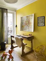 The children's playroom is in acidic tones, there is a vintage furniter but also pieces by Philippe Starck, on the wall the school map dialogues with the framed graffiti by Jon One. 
