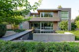 A stone walkway floats over an entry water feature, guiding visitors to the home.