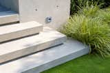 Floating concrete stairs lead visitors to the rear entertainment terrace.