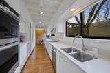 Galley kitchen with double oven and two large windows - sunny in the winter, shaded in the summer.