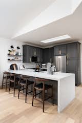 The combination of the oak floors, deep grey cabinetry, light quartz countertops, brass hardware and open shelving is such a timeless combination.