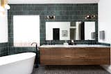 This emerald green tile is like the finale of the home. We love how the horizontal walnut grain carries through all of the cabinetry.