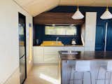 Kitchen, Cooktops, Light Hardwood Floor, Ceiling Lighting, Drop In Sink, Plywood Floor, Wood Counter, White Cabinet, and Refrigerator Kitchen  Photo 7 of 29 in The Hideaway at Baxters Harbour by Melissa Laforge