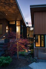 Material expression and exterior finishes were carefully selected to reduce the apparent size of the house, last through many years, and add warmth and human scale to the home. The unique siding system is made up of different widths and depths of western red cedar, complementing the vision of the structures wings which are balanced, not symmetrical. The exterior materials include a burn brick base, powder-coated steel, cedar, acid-washed concrete and Corten steel planters.  A private guest suite it tucked into the third level of the house opening to a reflective center garden court recessed into the home’s north and south halves. The setting provides a private entry and recessed quiet porch focused on northwest flora, river-rock and a unique rain-chain celebrating the region’s precipitation.
