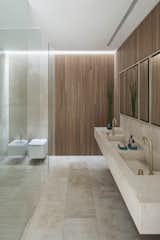 Bath Room, Wood Counter, Marble Wall, Ceiling Lighting, Two Piece Toilet, Travertine Floor, and Drop In Sink  Photo 17 of 21 in Casa en Dorrego by  Architect Jorge Muradas