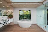 The master suite bathroom has a deep soaking tub, indoor and outdoor showers, and book-matched Panda marble. 