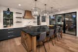 Ultra-modern farmhouse kitchen with "X" detail range hood and two tone blue cabinets
