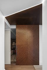 Custom walnut door, metal ceiling and light detail at playroom