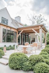 The indoor outdoor living is defined by large steel and glass doors that open to a covered barbecue area. The natural wood and white finishes are an extension of the home's interior design.