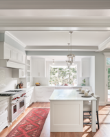 Kitchen, Accent Lighting, Marble Counter, Range, Pendant Lighting, Ceiling Lighting, White Cabinet, Medium Hardwood Floor, Ceramic Tile Backsplashe, Range Hood, and Drop In Sink Kitchen   Photo 9 of 30 in Gray Gables by Tongue & Groove Design + Build