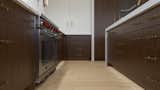 Kitchen, Marble Counter, Refrigerator, Wood Cabinet, Wall Lighting, Marble Backsplashe, Range, Light Hardwood Floor, and Pendant Lighting Kitchen Details - Yacht Modern Home in Wrightsville Beach  Photo 10 of 16 in Yacht Modern Home in Wrightsville Beach by Tongue & Groove Design + Build