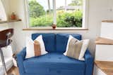 This adorable blue love seat folds out into a sleeper. The curved staircase beside the couch has a bookshelf built within it that you can access while seated