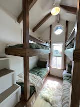 A tiny home with 2 sets of bunk beds (4 twin beds), 5 beds total, can sleep 8 with the couch. 6 people living in this tiny home. Storage staircase leading up.