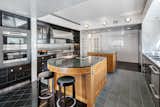 Stainless steel appliances are set against wood, marble, and slate floors; Thassos marble tiles clad the wall. Two built-in pantries and a walk-in pantry allow for ample storage without clutter.&nbsp;&nbsp;