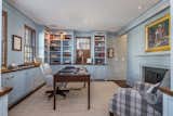 The office features custom built-ins painted a soft shade of blue.