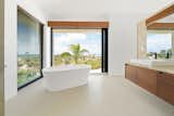 A spa-inspired bathroom with deep soaking tub beside a sliding door provides a setting for bathing with a fresh breeze.