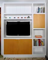 Mike Secore at MHS Architectural Millwork in Marlborough, New Hampshire, crafted the built-in maple cabinetry in the den for the television, books, and games.