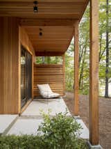 “We designed the landscape and house in tandem to ensure continuity between the exterior and interior,” diNiord says. An outdoor sling chair by Croft House sits in front of the outdoor shower under the covered patio in front of the primary bedroom.