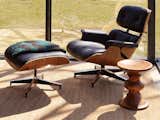 An Eames Lounge Chair and Ottoman and Eames Walnut Stool, Shape B, both by Charles and Ray Eames, are part of the package.