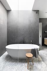 There's a skylight over the sculptural freestanding soaking tub in the primary bath. Leon Lebeniste made the stool.