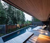 Angled, sloping pickets function like Venetian blinds between the board-formed concrete volumes and tall vertical grasses provide another layer of screening.  An ipe deck with a waterfall design runs parallel to the pool.