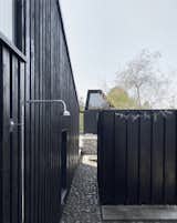 The painted black wood facades vary. Some feature wide slats on a fixed board, others feature thin ones. 