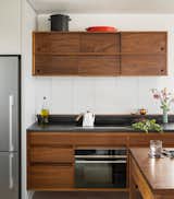 “I like the darkness of walnut. Other woods tend to yellow if you don’t stain it, while walnut stays true to itself,” Caleb says. The white glass tile backsplash melds with the wall.