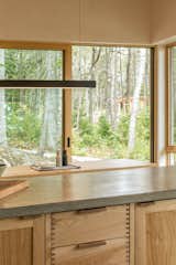 Mid-Coast Maine Camp by Winkelman Architecture kitchen peninsula dining table