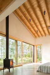 The homeowners’ sleeping area opens wide to the outdoors and a wood-burning stove supplements the geothermal and solar-powered systems.