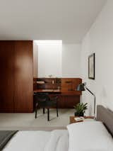 One of the guest bedrooms is illuminated by a skylight in the corner, above a built-in desk.