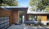 Exterior, Shed RoofLine, Concrete Siding Material, Metal Roof Material, Stone Siding Material, Metal Siding Material, House Building Type, and Wood Siding Material Front door with hallway open to the lake beyond  Photo 3 of 14 in Holland House by Robert Neylan