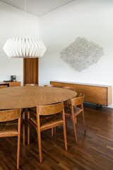 Dining Room, Table, Lamps, Pendant Lighting, Chair, Dark Hardwood Floor, and Storage dinner table  Photo 9 of 29 in Pindaibeiras House by André Scarpa