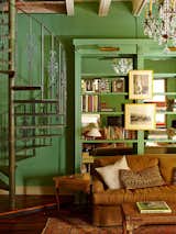 Vibrant green sitting room with spiral staircase to the upstairs bedroom.
