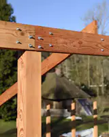 A modern timber frame rises in the midst of the chalet it is replacing