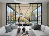 The division between indoor and outdoor spaces is defined by sleek glass and steel doors.
