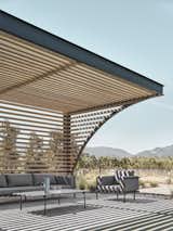 A custom trellis shades the seating area for the adjacent tennis courty.