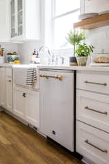 Hitting on the ever-popular design trend of mixed metals, the kitchen features Big Chill's Classic Dishwasher in White with Brushed Brass trim.