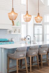 The kitchen includes crisp white cabinets and shiplap installed throughout to create a refreshing contrast in the space.
