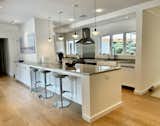 Kitchen, Cooktops, White Cabinet, Medium Hardwood Floor, Accent Lighting, Refrigerator, and Drop In Sink  Photo 10 of 10 in Shelter Island Retreat by Michael Lewis