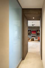 One of the thick stucco walls transitions to the hall.  Reglets create shadows where the walls meet the ceiling plane.