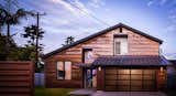 Corten steel sheets replace painted wood exterior siding.  A cable-supported welded steel trellis guides the visitor to the generous glass front door.