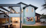 The steel trellis on the front of the house is repeated in the back, adding movable sunshades over outdoor dining.  The bi-fold glass door in the dining room and a pass-through window in the kitchen reinforce the indoor-outdoor connection.