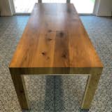 A custom dining table made from the curved oak flooring was commissioned by the clients. The curves in the wood provide a contrast that emphasizes the minimalist form of the gathering table. The inner edges of the table are a hard maple bull nose that create a soft tactile connection to the table but also connect to the maple shelving in the kitchen tonally.