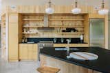 Kitchens feature floating open shelves and custom cabinetry in finished oak. Baseboards, wood trim, and some ceiling and other wood paneling are sourced from wood harvested on the property and milled locally when possible. 