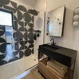 Bath Room, Engineered Quartz Counter, Vessel Sink, Ceramic Tile Wall, Open Shower, and Concrete Floor Bath with geometric tile and black vanity.  Photo 15 of 19 in Triple Gables by Dave Widmer
