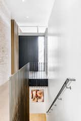 Asymmetrical stairs ascend to walls of Italian brick and Accoya paneling. 